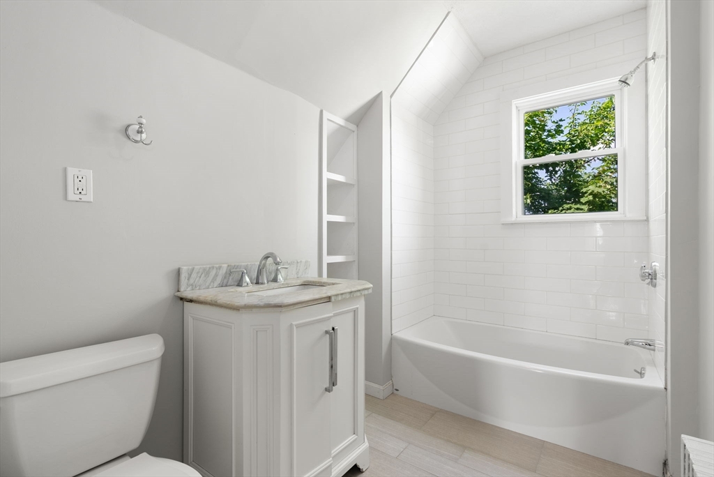 460 Beech Street Boston, MA 02131 - Photo 20 of 25 a bathroom with a granite countertop sink a toilet and bathtub