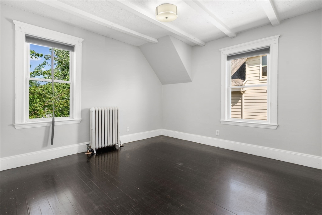 460 Beech Street Boston, MA 02131 - Photo 21 of 25 a view of an empty room with wooden floor and a window
