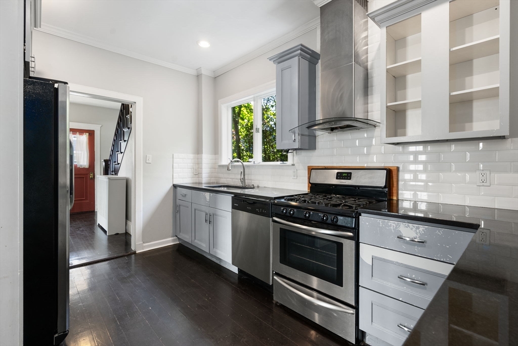 460 Beech Street Boston, MA 02131 - Photo 4 of 25 a kitchen with stainless steel appliances granite countertop a stove and a refrigerator