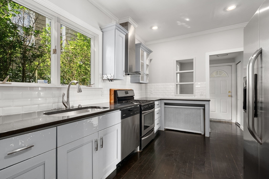 460 Beech Street Boston, MA 02131 - Photo 5 of 25 a kitchen with a sink stove and cabinets