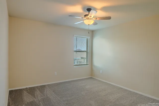 an empty room with a chandelier fan