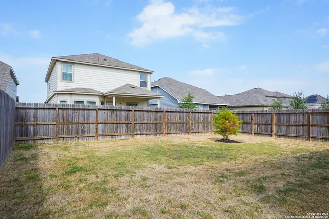 a view of a house with a yard and fence