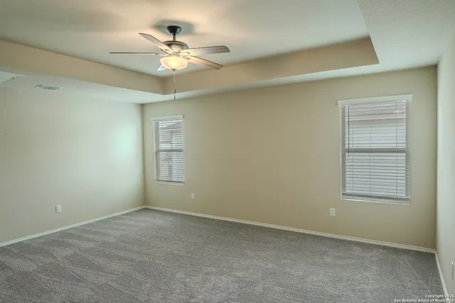 an empty room with a window and a ceiling fan