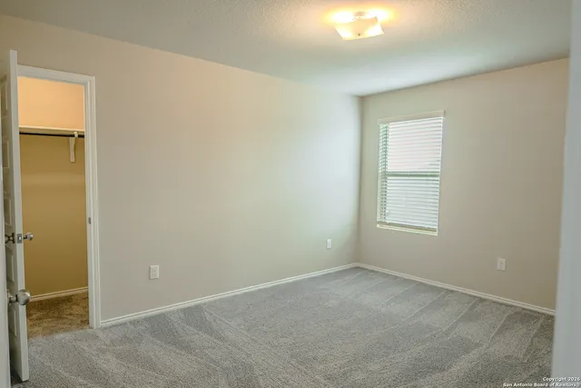 an empty room with windows and closet