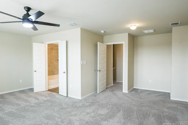 a view of an empty room and a ceiling fan