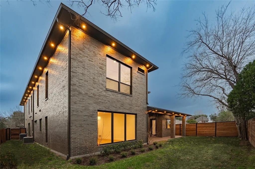 309 Kaye Street Coppell, TX 75019 - Photo 3 of 36 Contemporary brick exterior with large windows, recessed soffit lighting, a covered patio, and wood fencing