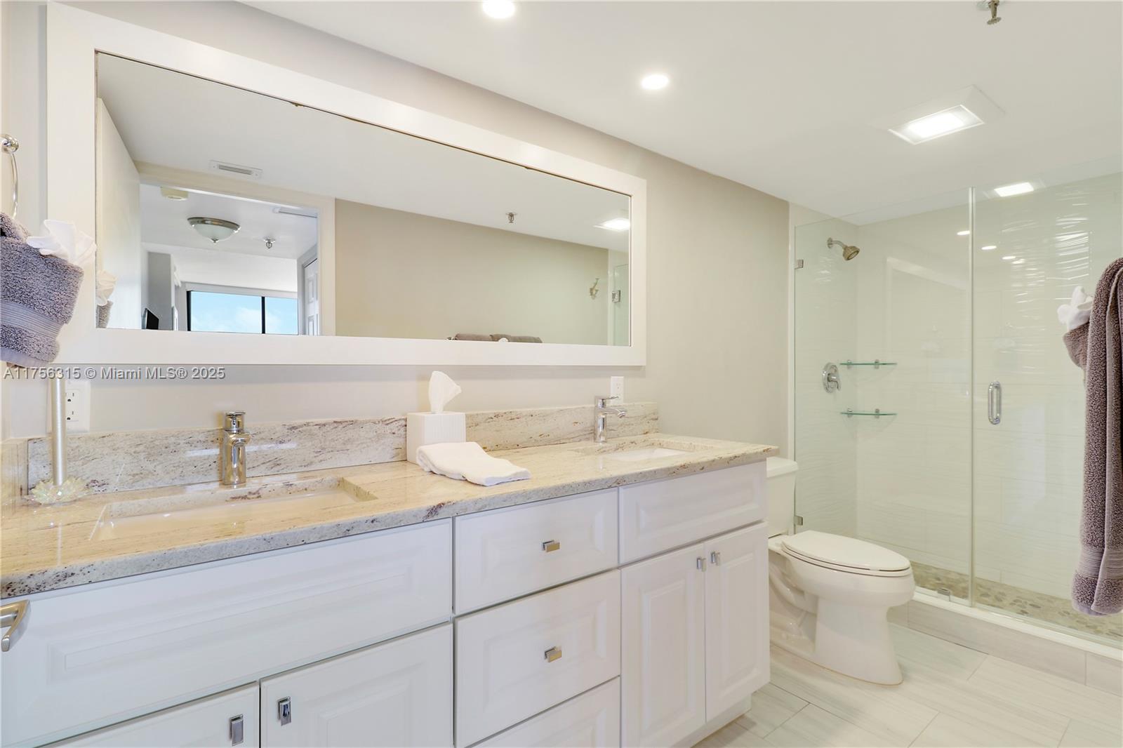 1300 Florida A1A, Unit 325 Jupiter, FL 33477 - Photo 19 of 44 a bathroom with a granite countertop sink a toilet and a mirror