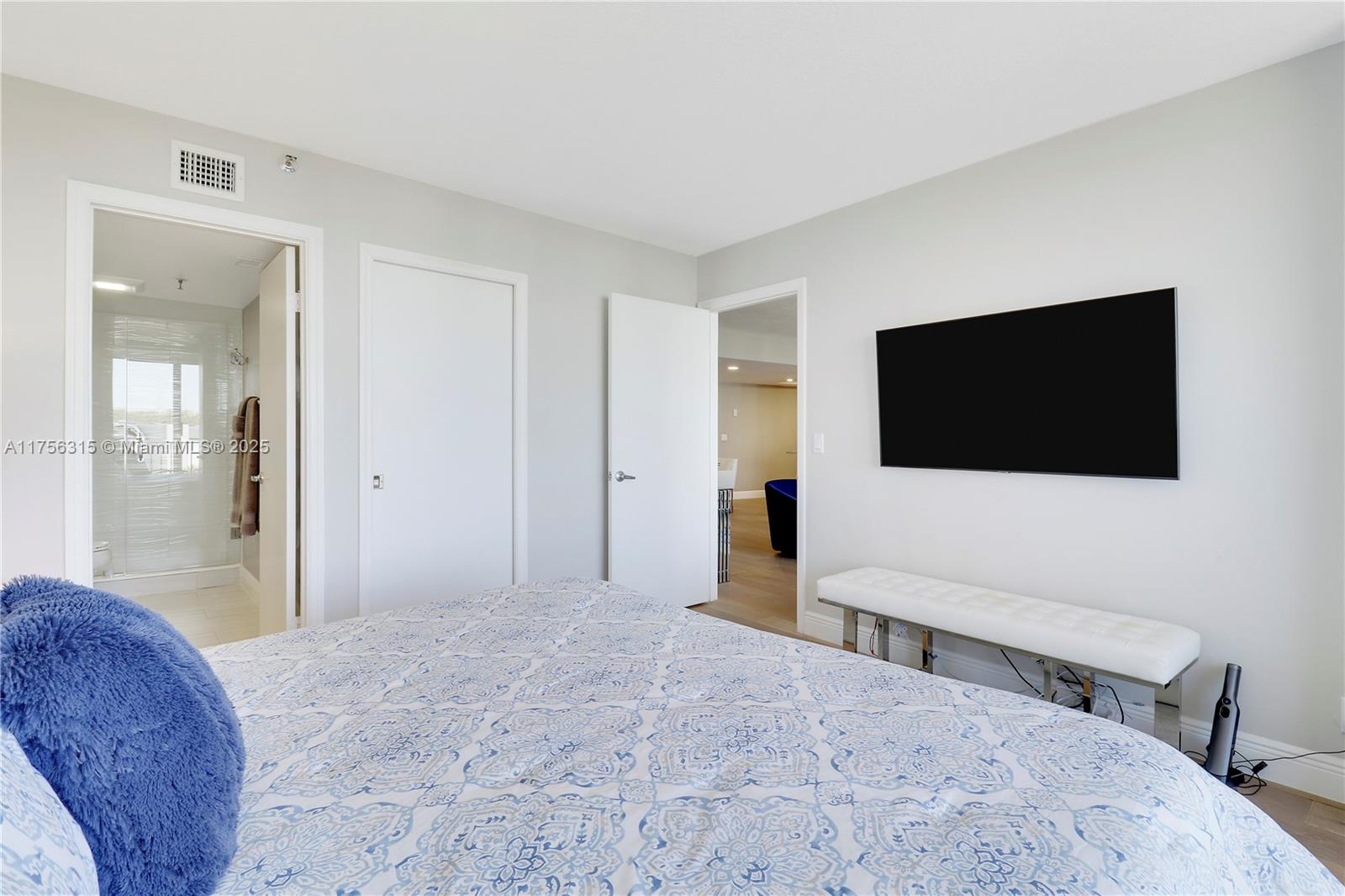 1300 Florida A1A, Unit 325 Jupiter, FL 33477 - Photo 22 of 44 a spacious bedroom with a bed and a flat screen tv