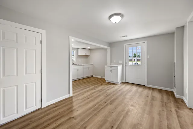 a view of empty room with wooden floor