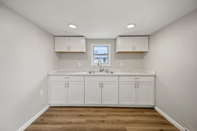 a view of cabinets a wooden floor and a window