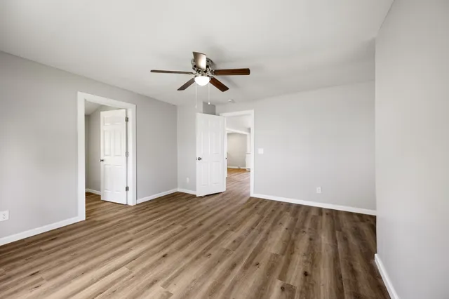 a view of room with wooden floor and ceiling fan