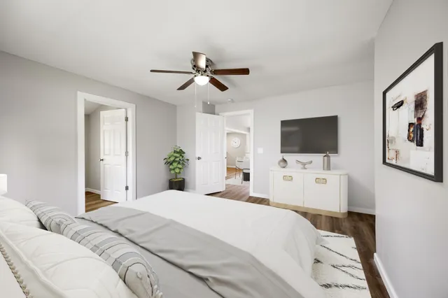 a bedroom with a bed window and a flat screen tv