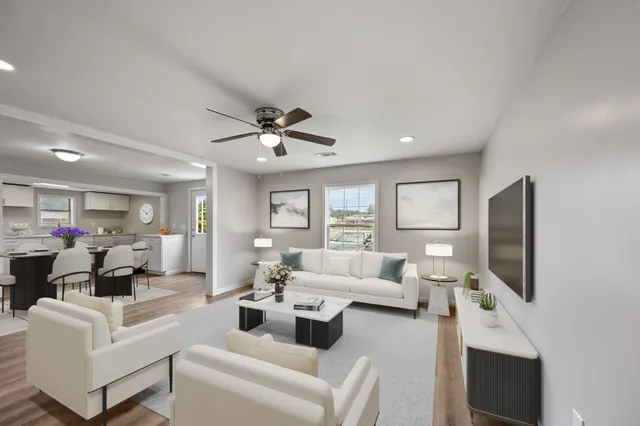 a living room with furniture a flat screen tv and a fireplace