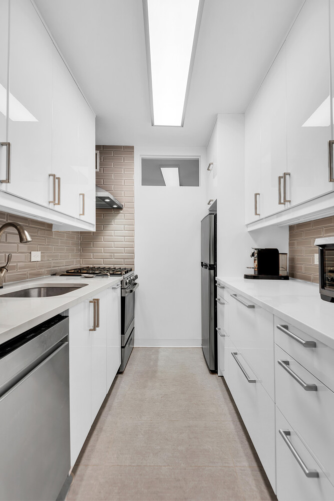 310 Lexington Avenue, Unit 9G Manhattan, NY 10016 - Photo 3 of 6 a kitchen with granite countertop white cabinets and refrigerator