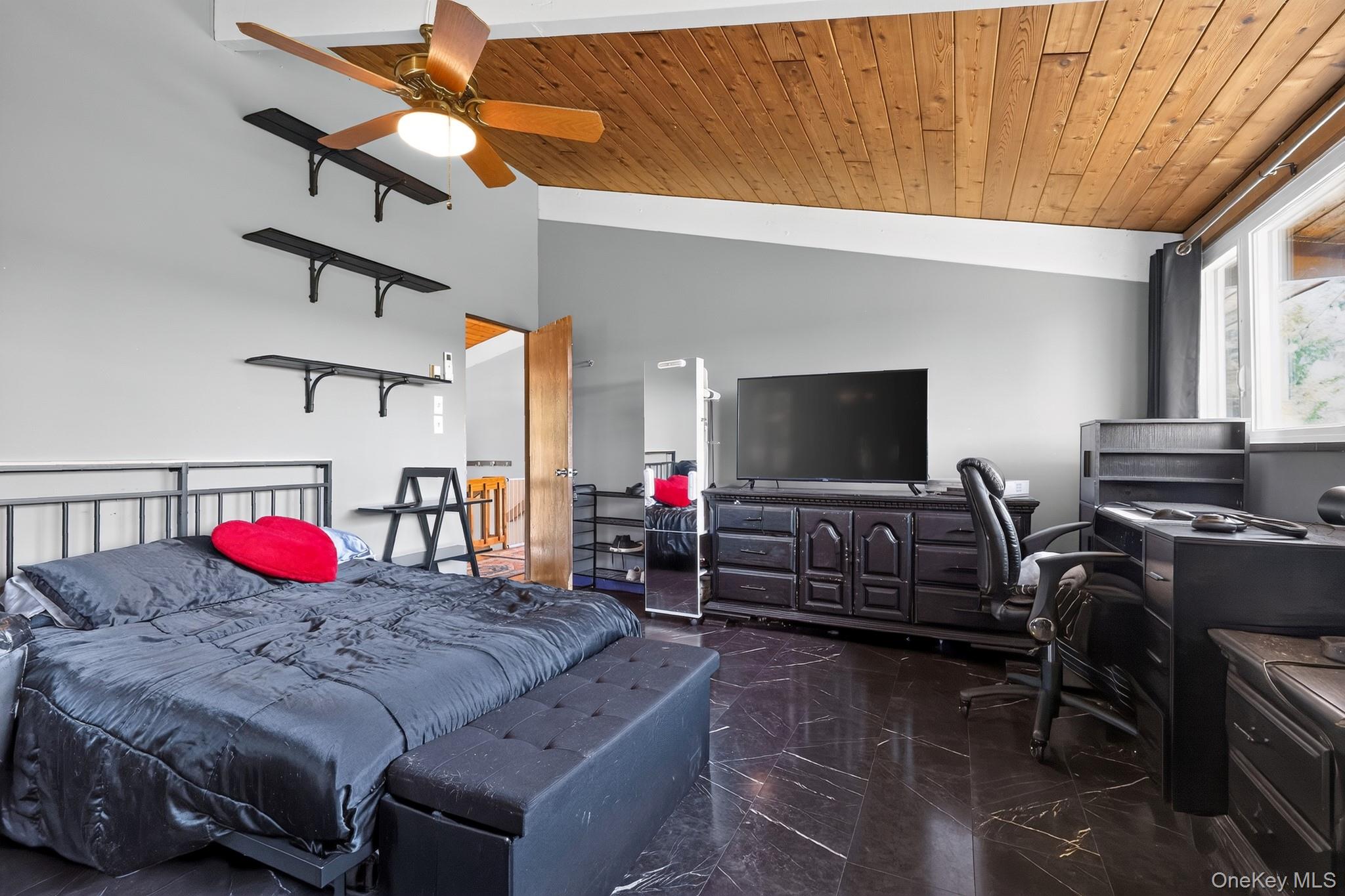 424 Laroe Road Chester, NY 10918 - Photo 9 of 43 Vaulted wood-paneled ceiling with a ceiling fan, dark-toned flooring, light gray wall finishes, and a window providing natural light