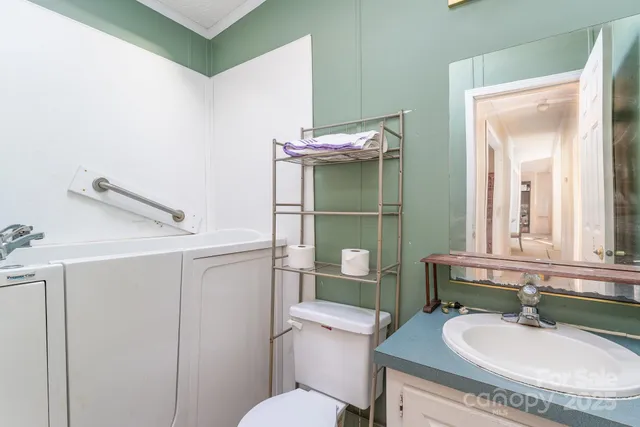 a bathroom with a granite countertop sink mirror vanity and toilet