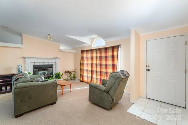 a living room with furniture a fireplace and a large window