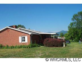 60 Osborne Farm Road Canton, NC 28716 - Photo 2 of 12 a backyard of a house with plants and large tree