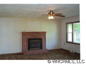 60 Osborne Farm Road Canton, NC 28716 - Photo 7 of 12 a view of a livingroom with a fireplace a ceiling fan and wooden floor