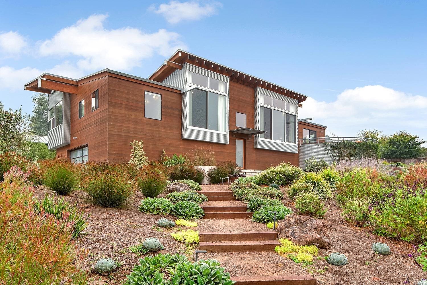 a front view of a house with a yard and potted plants