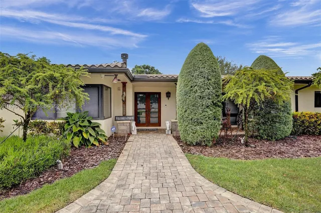 a front view of a house with a garden