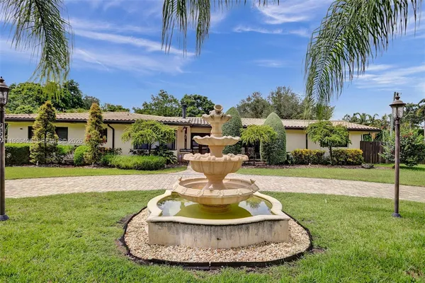 a view of a house with a swimming pool and a yard