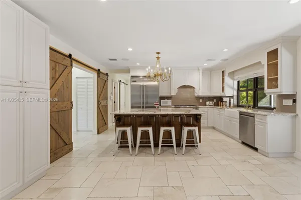 a kitchen with kitchen island granite countertop a counter top space appliances and a view of living room