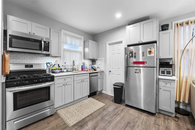 a kitchen with stainless steel appliances granite countertop a refrigerator stove and sink