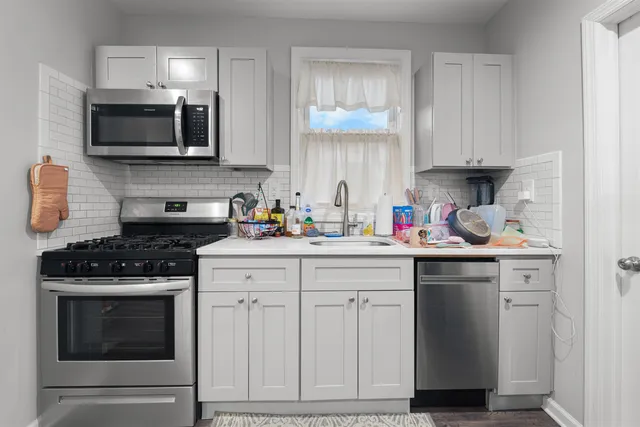 a kitchen with cabinets appliances and a sink