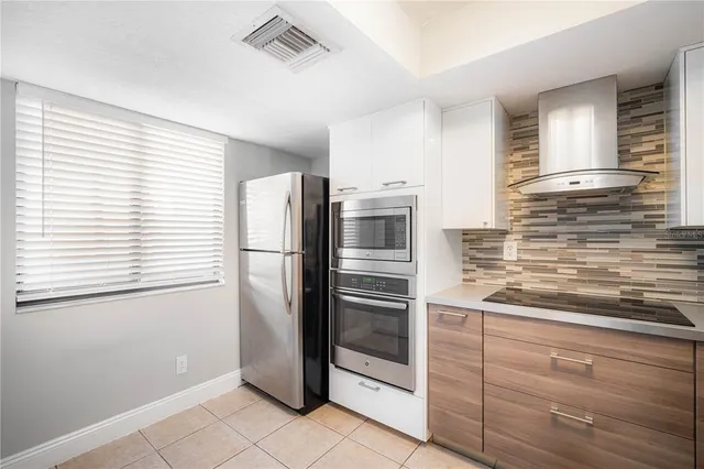 a kitchen with granite countertop white cabinets and appliances