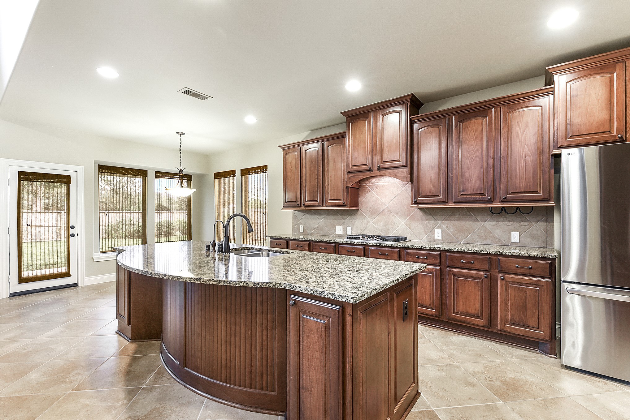 29023 Powder Ridge Drive Katy, TX 77494 - Photo 20 of 50 Enjoy lovely views of the home and backyard while working in the kitchen or hosting guests. Across from the kitchen, the spacious formal dining room offers a convenient layout for entertaining, with easy access to the backyard—perfect for BBQs and outdoor gatherings.