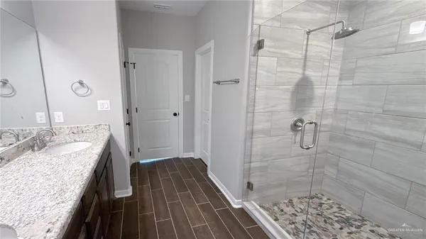 a bathroom with a granite countertop sink a shower and a mirror