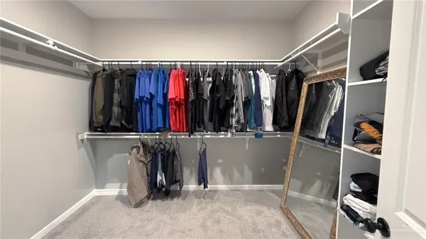 a view of walk in closet with clothes