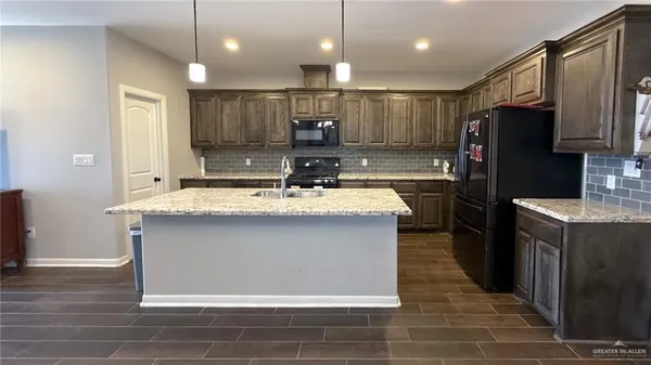 a kitchen with kitchen island a sink stainless steel appliances and counter space