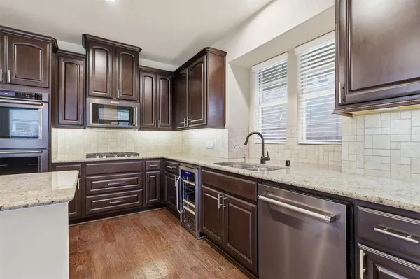 a kitchen with stainless steel appliances granite countertop a sink and cabinets