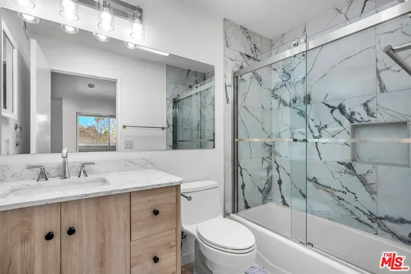 a bathroom with a sink vanity mirror and toilet