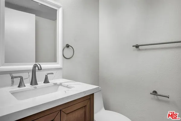 a bathroom with a sink toilet and a mirror