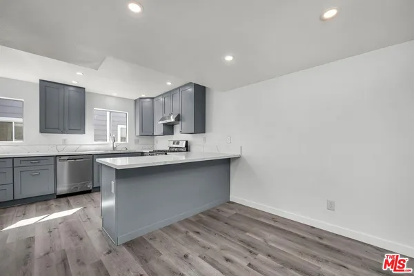 a kitchen with a sink cabinets and wooden floor