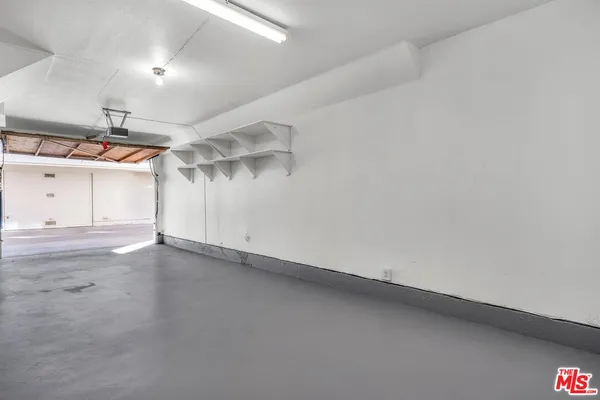 an empty room with ceiling fan and windows