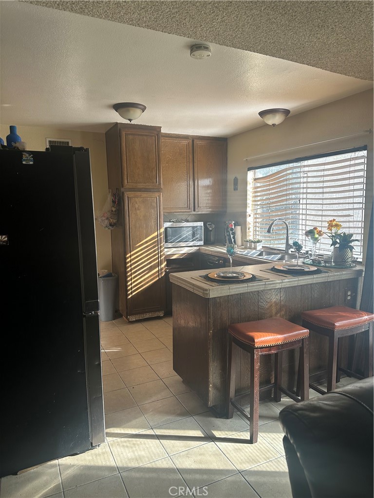 943 West Valencia Street Rialto, CA 92376 - Photo 4 of 18 a kitchen with stainless steel appliances granite countertop a sink and a refrigerator