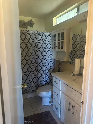 a bathroom with a granite countertop toilet and a sink