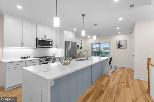 a large kitchen with kitchen island a sink stainless steel appliances and cabinets