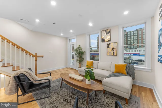 a living room with furniture and a wooden floor