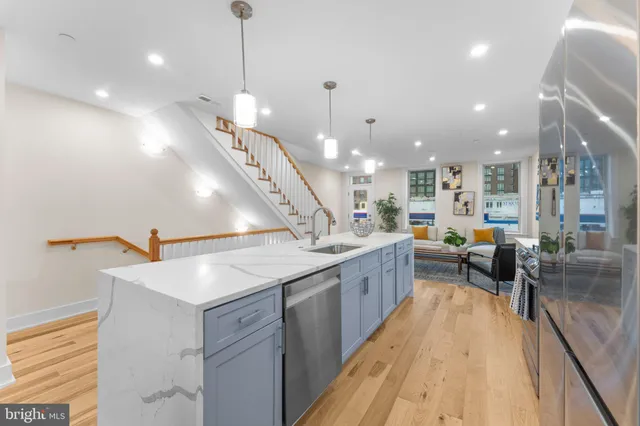 a kitchen with a sink a counter top space stainless steel appliances and a chandelier
