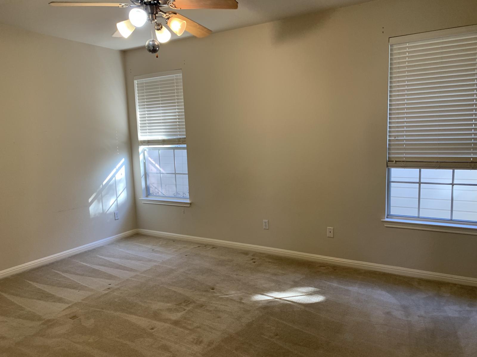 11000 Anderson Mill Road, Unit 29 Austin, TX 78750 - Photo 17 of 27 an empty room with windows and chandelier fan