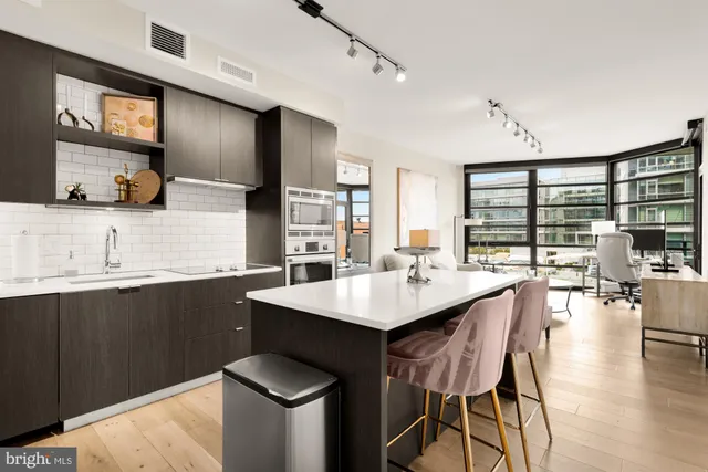 a kitchen with a table chairs sink and wooden floor