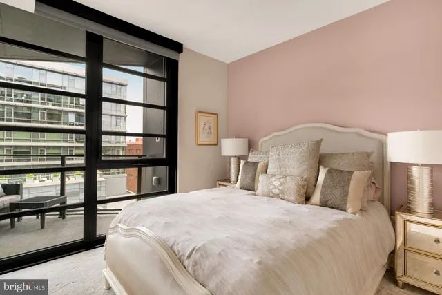 a bedroom with a bed and a large window