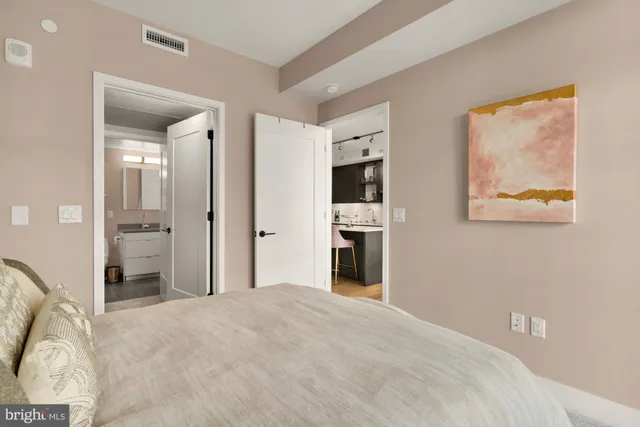 a bedroom with a bed and a painting on the wall