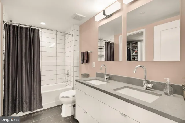 a bathroom with a double vanity sink toilet and shower