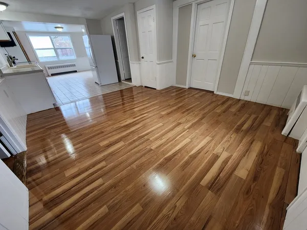 a view of empty room with wooden floor